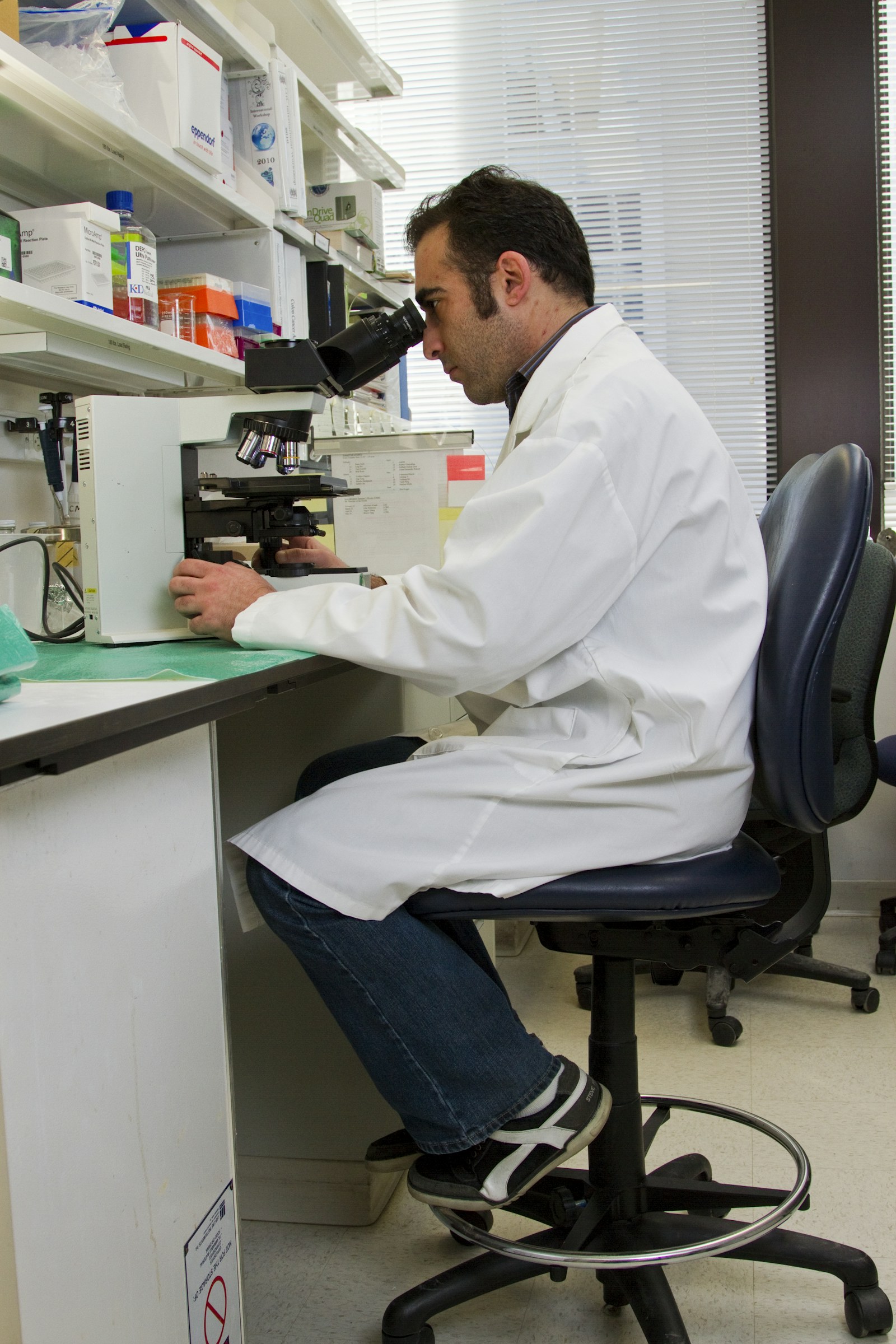 Scientist examining a medical research sample through a microscope